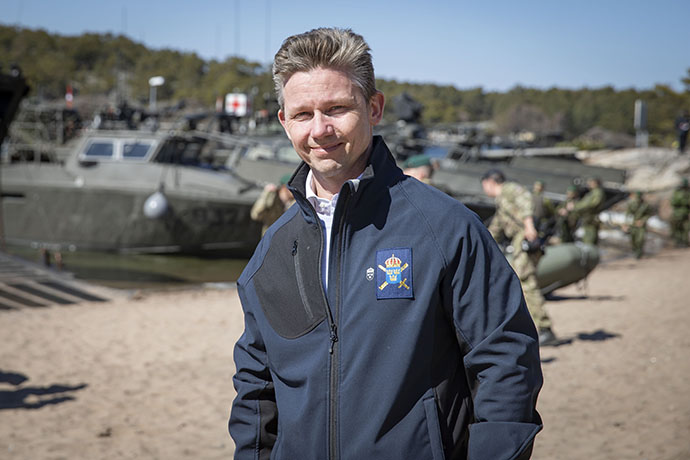 Försvarsminister Pål Jonson med stridsbåtar i bakgrunden