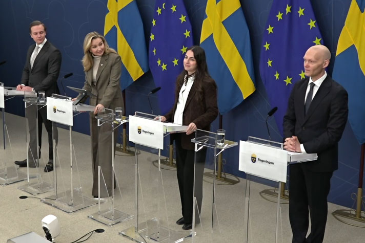 De medverkande är avbildade snett ovanifrån och står bakom var sin talarstol. I fonden Sveriges och EU-s flagga.