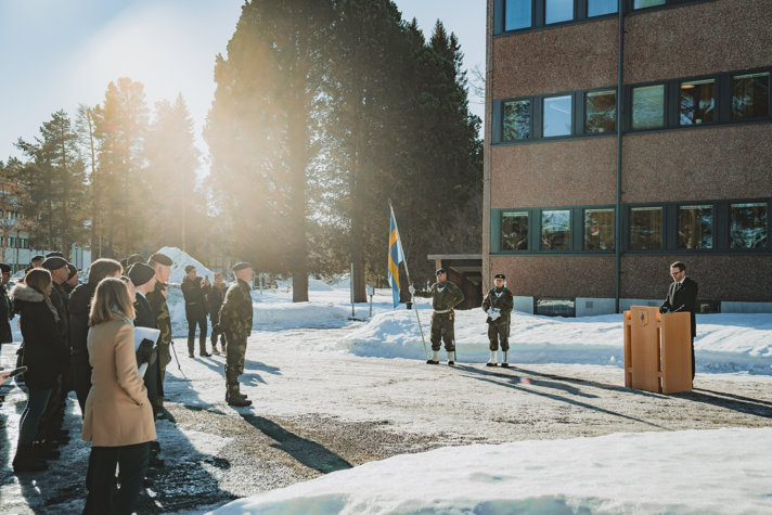 Andreas stående utomhus vid en talarstol i snön.