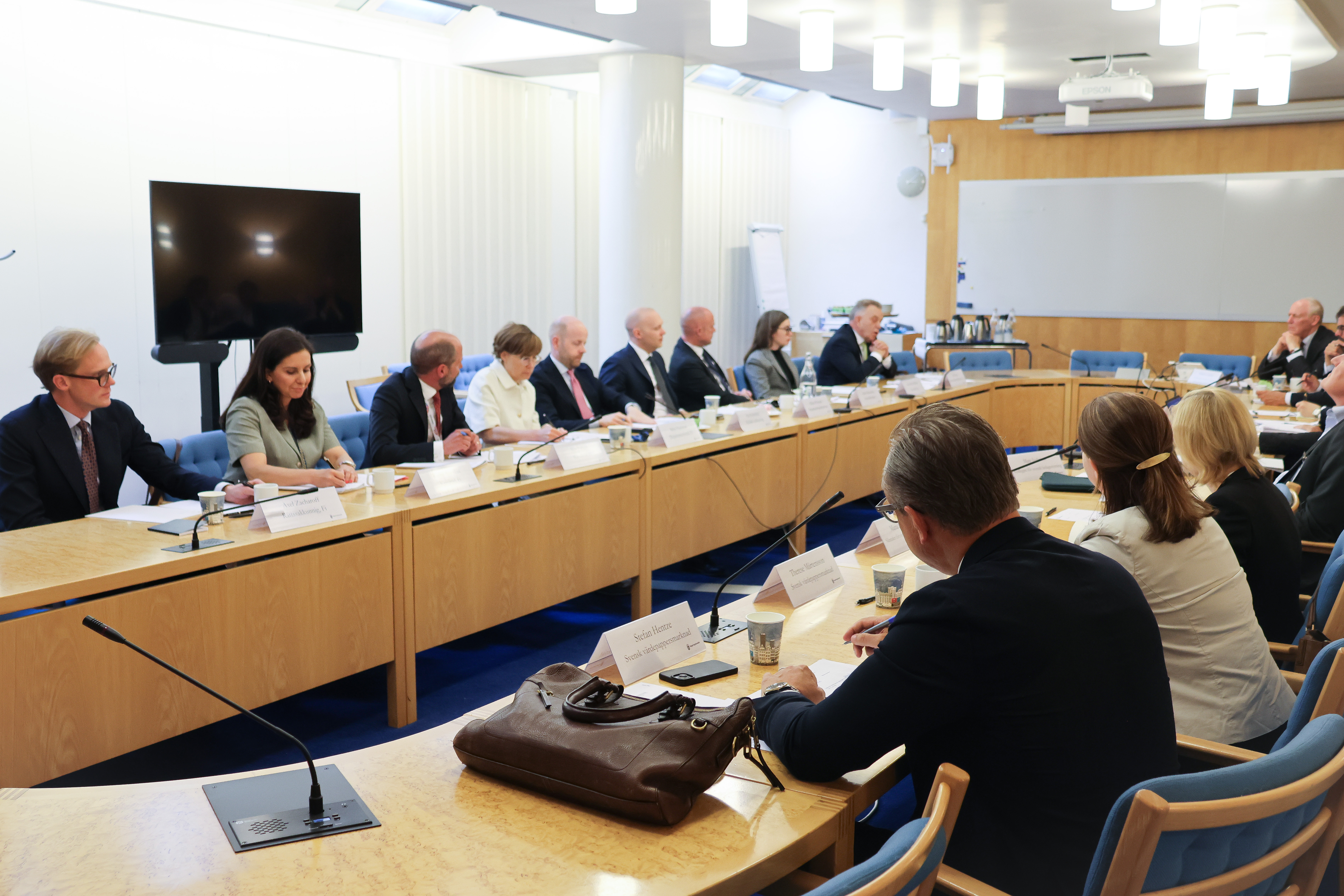 Ett tjugotal personer sitter i ett mötesrum när de har ansiktena mot varandra.