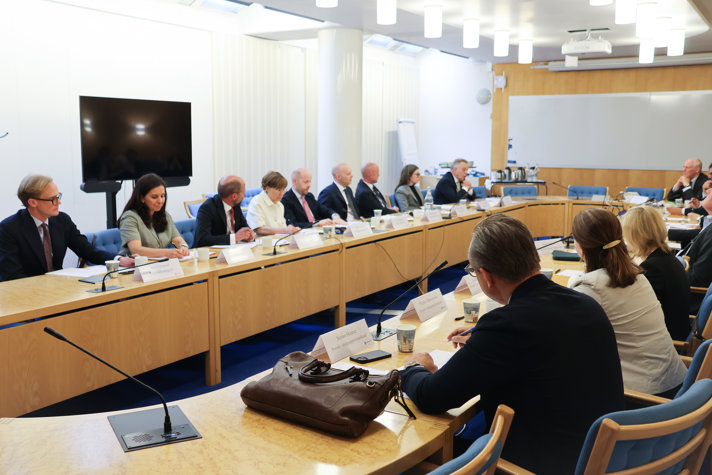 Ett tjugotal personer sitter i ett mötesrum när de har ansiktena mot varandra.