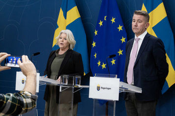 Camilla Waltersson Grönvall och Martin Valfridsson står bakom var sitt podium i regeringens pressrum.