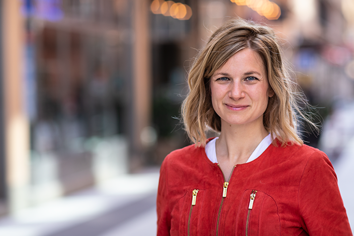 Bild på Fanny von Heland i röd jacka på en gata.