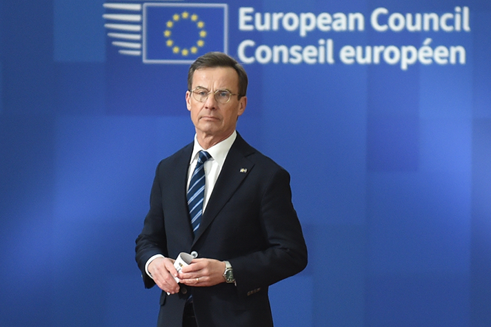 Ulf Kristersson framför en fotovägg med texten "European Council".