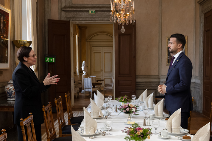 Maria Malmer Stenergard och president Jakov Milatović står vid ett middagsbord och samtalar med varandra.