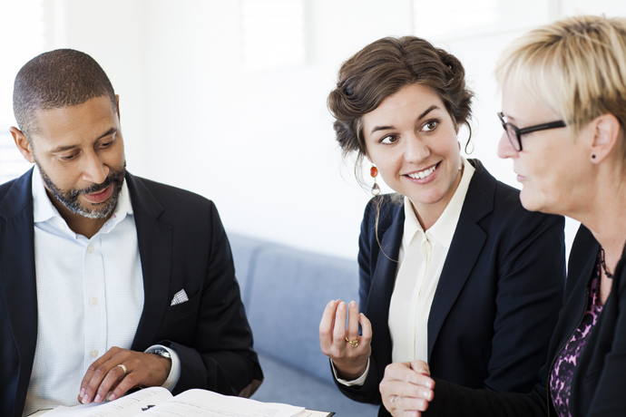 En man och två kvinnor sitter i möte.