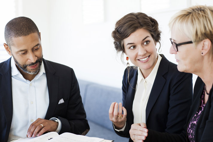 En man och två kvinnor sitter i möte.