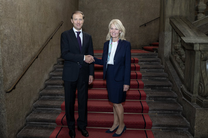 Anna Hallberg och Denis Manturov skakar hand i en trappa