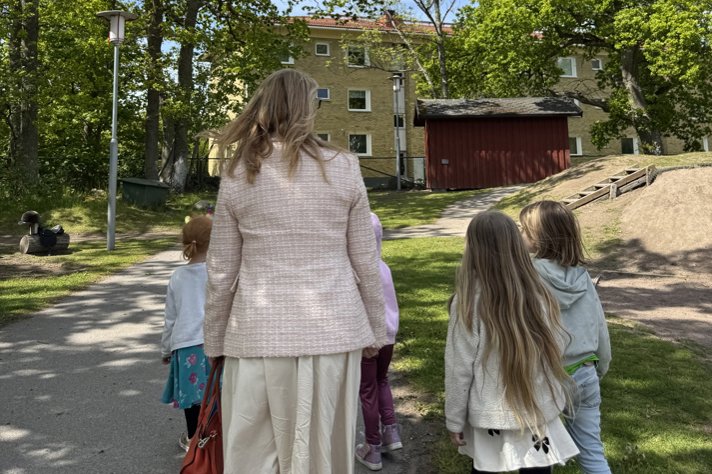 Skolministern och några barn är på en skolgård