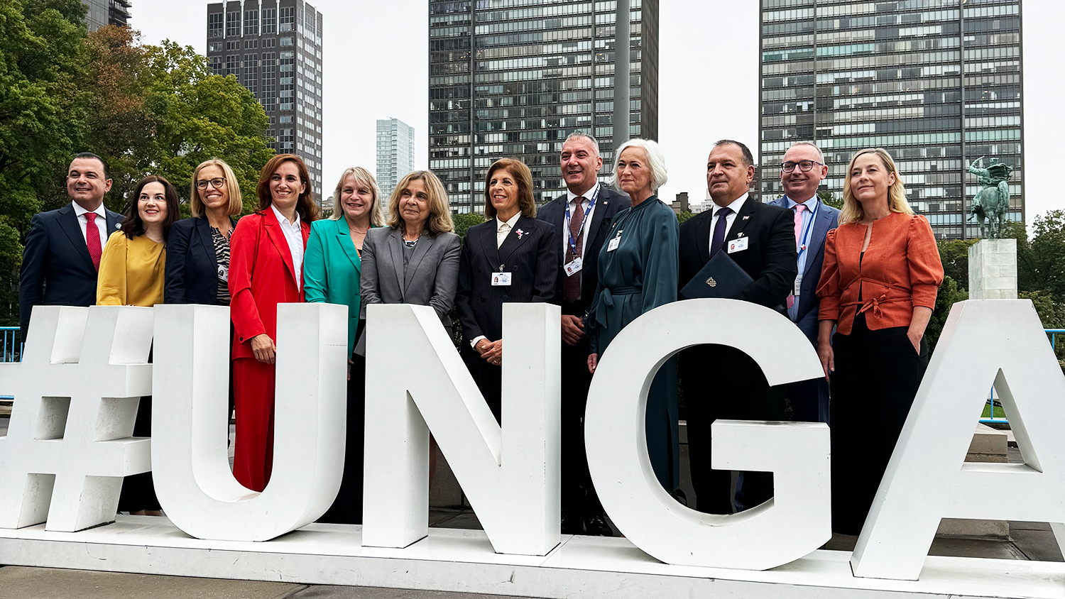 Foto på en grupp personer, de står bakom en stor skylt med ordet UNGA