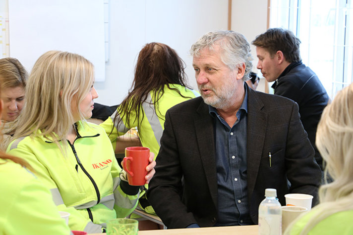 Bostads- och digitaliseringsminister Peter Eriksson sittandes vid ett bord med kvinnliga lärlingar