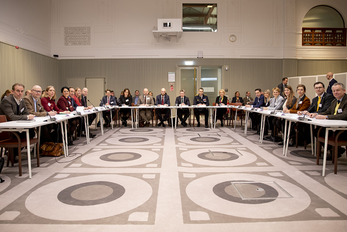 Flera personer sitter runt ett bord inomhus.
