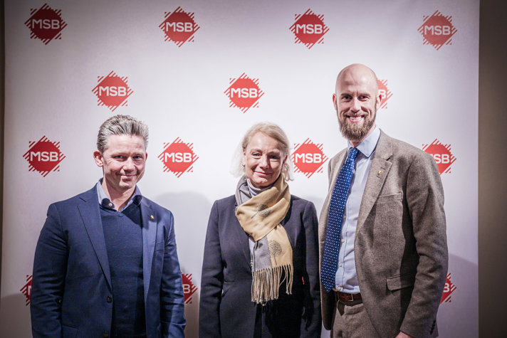 På bilden står försvarsminister Pål Jonson, MSB:s generaldirektör Charlotte Petri Gornitzka och minister för civilt försvar Carl-Oskar Bohlin framför en backdrop med MSB:s logga