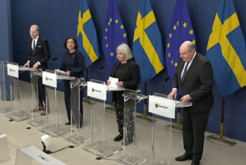 Fyra personer avbildade snett uppifrån bakom var sin talarstol