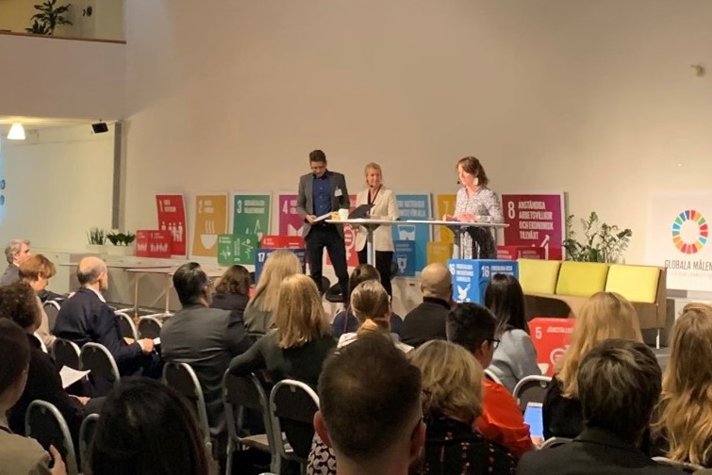 Ministern för internationellt utvecklingssamarbete, Matilda Ernkrans, på panelen med två andra och publiken i förgrunden