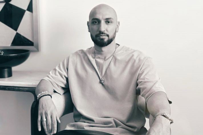 Ilya Salmanzadeh sitter på en stol och tittar in i kameran.