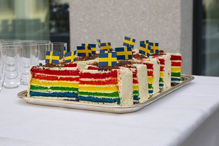 Regnbågsfärgade bakelser med små svenska flaggor nedstuckna i toppen.