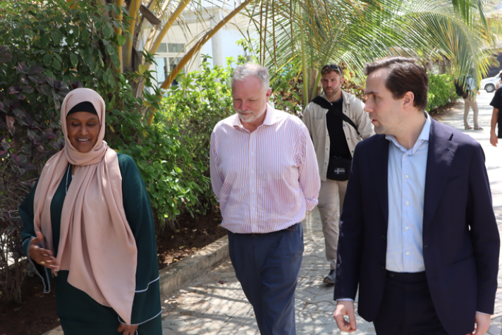 Bistånds- och utrikeshandelsminister Benjamin Dousa promenerar tillsammans med två andra vid Elman Peace Center i Somalia.