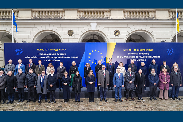 Gruppbild på mötesdeltagarna som står utomhus framför en fotovägg med texten "Lviv 10-11 December 2025. Informal meeting of EU ministers for EU Affairs with Ukraine".