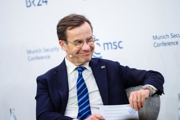 Statsminister Ulf Kristersson sitter i ett panelsamtal, men en bakgrund med Munich Security Conferances logotyp.