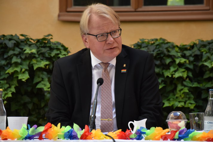 Peter Hultqvist vid ett bord med mikrofoner och girlander.