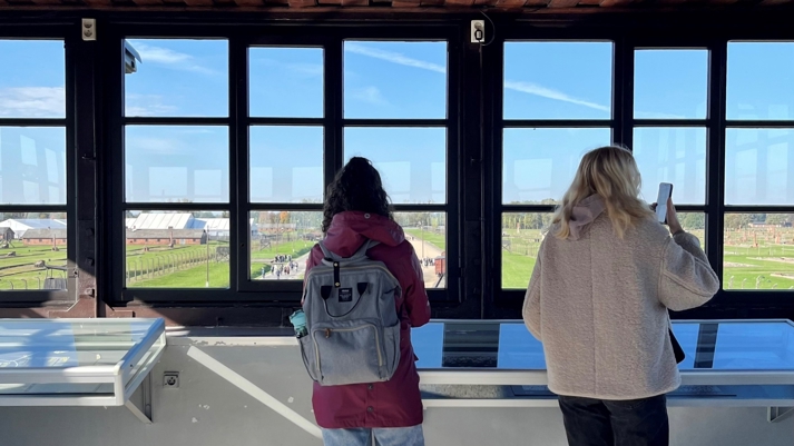 Elever tittar ut över förintelselägret Auschwitz-Birkenau.