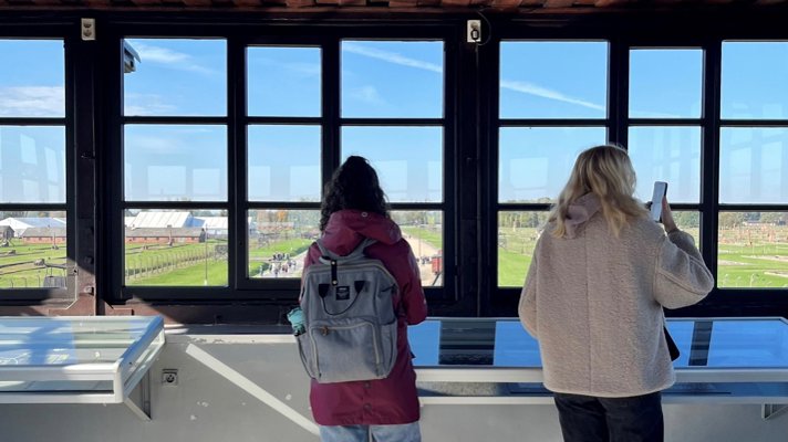 Elever tittar ut över förintelselägret Auschwitz-Birkenau.