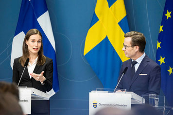 Finlands statsminister Sanna Marin och statsminister Ulf Kristersson i var sin talarstor framför en fond av Sveriges och Finlands flaggor