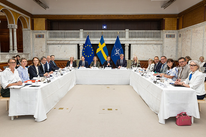Statsminister Ulf Kristersson, justitieminister Gunnar Strömmer, socialminister Jakob Forssmed, socialtjänstminister Camilla Waltersson Grönvall och jämställdhetsminister Nina Larsson sitter runt ett bord under mötet i Rådet för kvinnofrid.