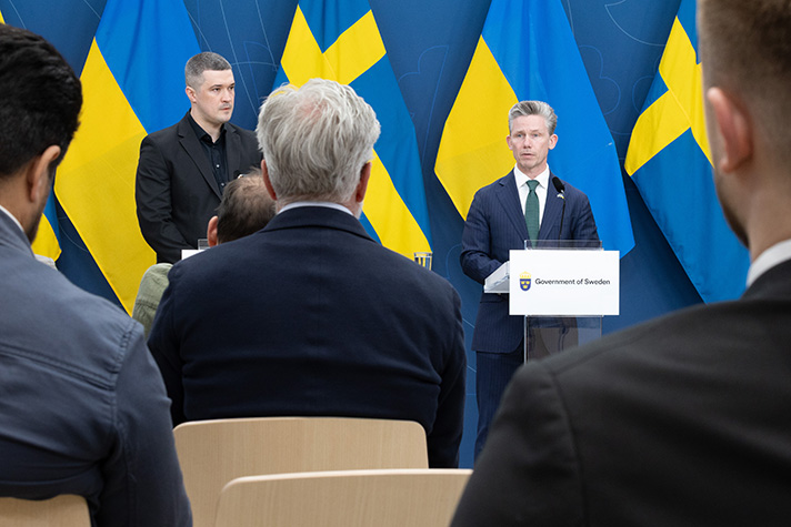 Mykhail Fedorov och Pål Jonson under pressträffen som de höll tillsammans. I bakgrunden syns en blå fond och de svenska och ukrainska flaggorna. I förgrunden syns ryggtavlorna på några av de journalister som deltog på pressträffen.