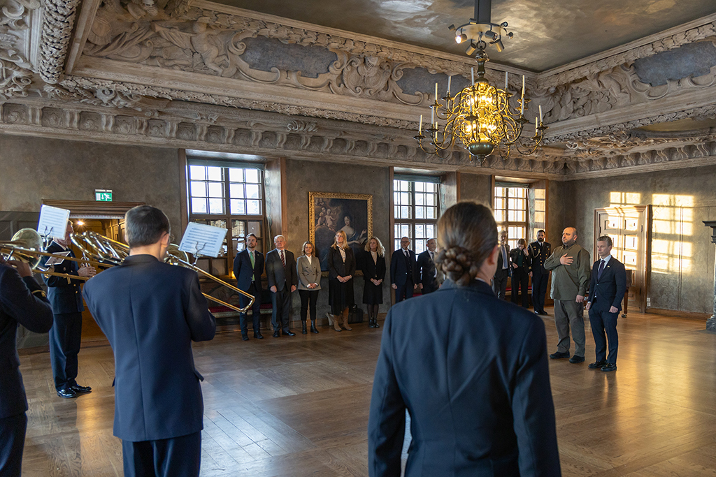 Umjerov och Jonson står givakt i mitten av ett stort paradrum på Karlbergsslott och lyssnar till när musikkåren spelar Sveriges och Ukrainas nationalsånger. 