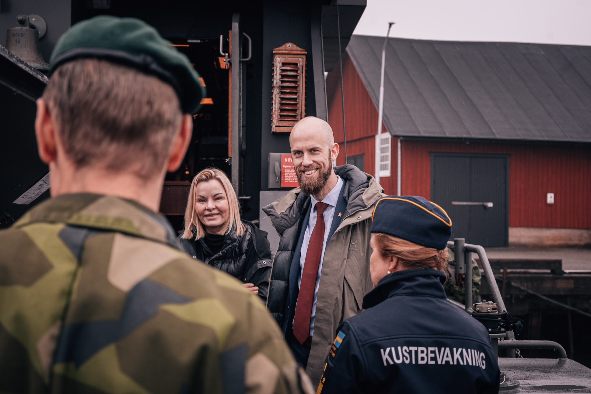 Ulrika Odén, ämnesråd försvarsdepartementet, Carl-Oskar Bohlin och Therese Mattsson, Kustbevakningens generaldirektör står tillsammans och pratar med en amfibiesoldat. 