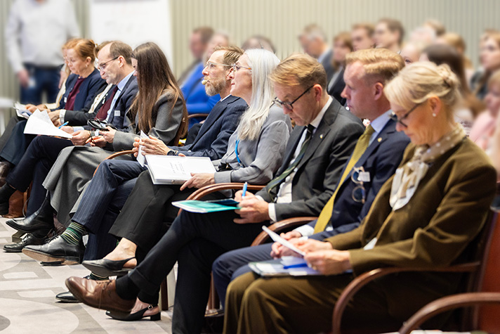 På bilden syns främre raden av publiken på konferensen. Deltagarna som syns på bilden är: Ann Lindberg, Generaldirektör på Läkemedelsverket, Jakob Granit, Generaldirektör på SIDA, Veronika Gryschenko, rådgivare till Ukrainas hälsominister, Jakob Forssmed, socialminister, Caroline Agrell, politiskt sakkunnig åt socialminister Jakob Forssmed, Björn Eriksson, Generaldirektör på Socialstyrelsen, Andreas Sandgren, enhetschef på enheten för antibiotika och vårdhygien på Folkhälsomyndigheten, Karin Tegmark Wisell, ambassadör för Global Hälsa