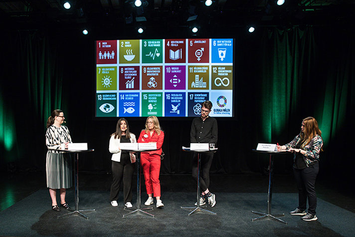 Anna Ekström står på en scen tillsammans med flera unga människor.