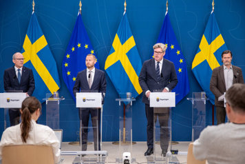 De medverkande står vid var sin talarpulpet.