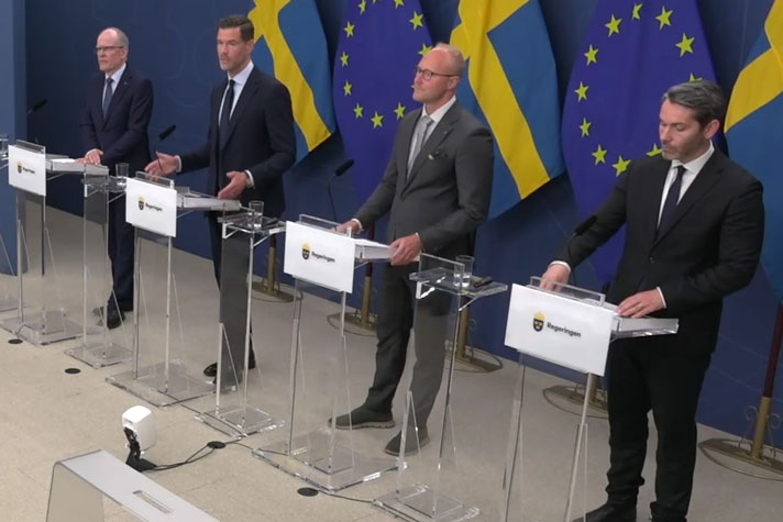 De fyra medverkande står vid var sin talarpulpet.