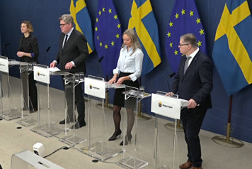 De medverkande i helfigur vid var sin talarpulpet avbildade snett framifrån.