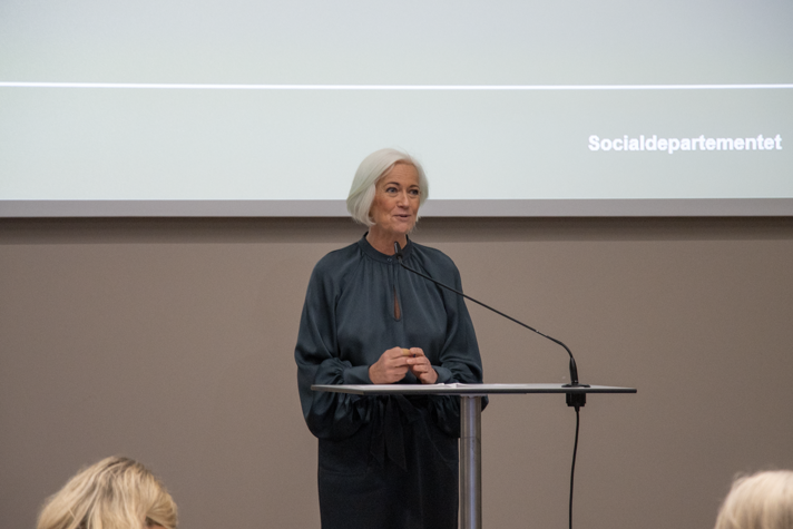 Acko Ankarberg Johansson står bakom en talarstol och talar.