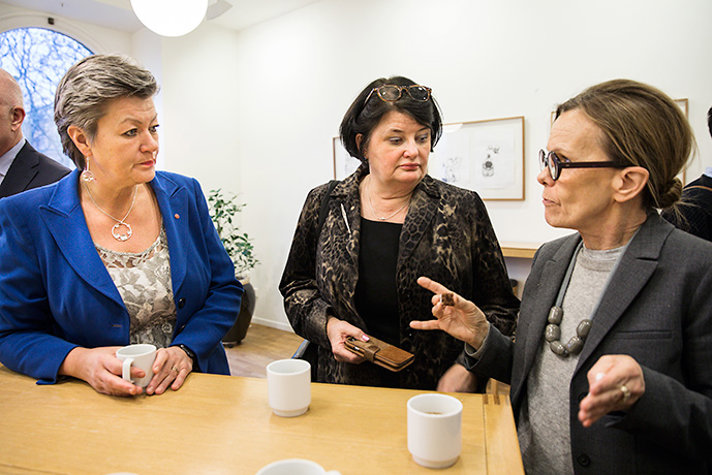 Ylva Johansson samtalar runt ett fikabord med Heike Erkers och Agneta Broberg