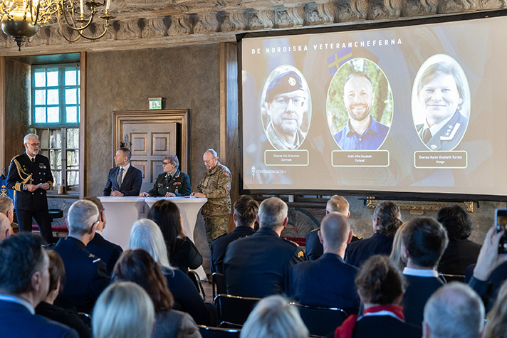 Veterancheferna från Norge, Danmark och Finland står vid ståbord framför publik.
