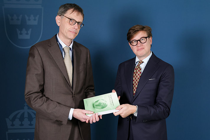 David Sikström och utredaren håller i ett exemplar av utredningens betänkande