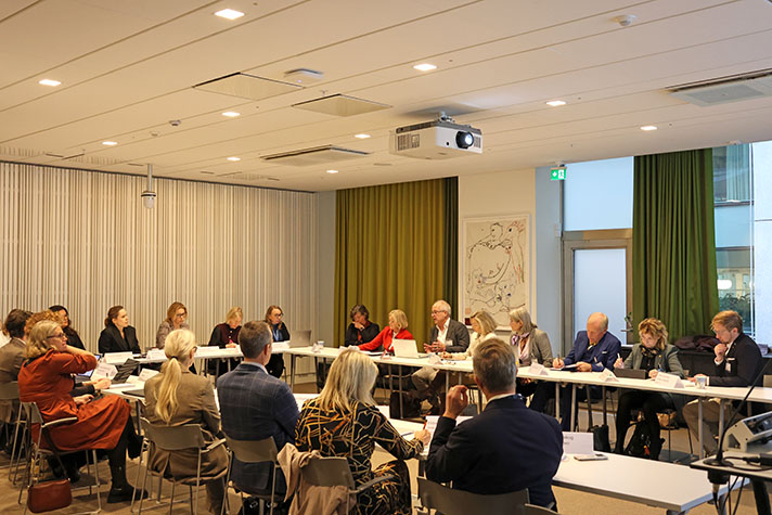 Deltagare i mötet runt långa konferensbord med statssekreterarna i mitten..