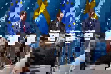Pål Jonson, Ulf Kristersson och Tobias Billström står vid varsitt talarbord i Regeringskansliets presskonferenssal. EU-flaggor och svenska flaggor i bakgrunden.