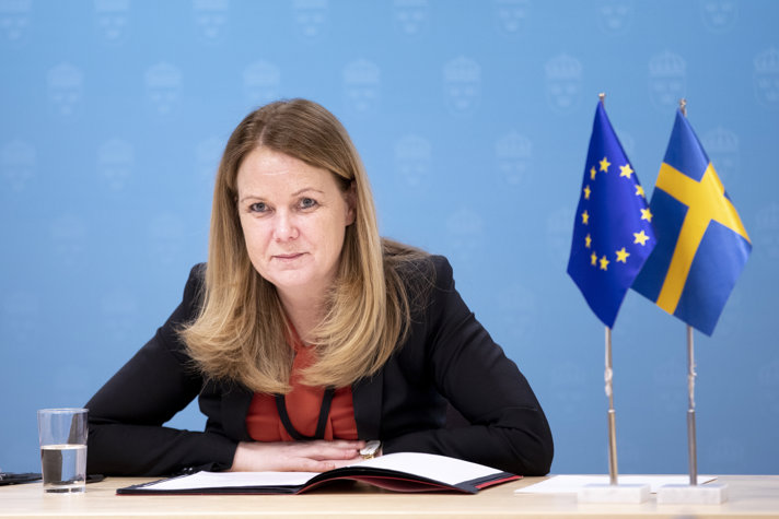 LAndsbygdsminister Jennie Nilsson vid ett bord med flaggor