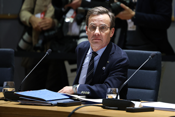 Ulf Kristersson sitter vid ett bord i mötesrummet.