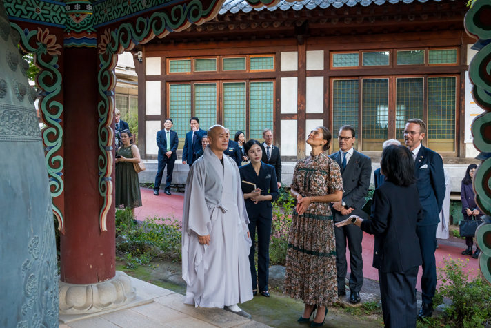 Kronprinsessparet och bostads- och infrastrukturminister Andreas Carlsson står vid tempel tillsammans med koreanska företrädare.