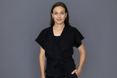 Porträttbild av statssekreterare Ulrika Hoff framför en grå bakgrund.