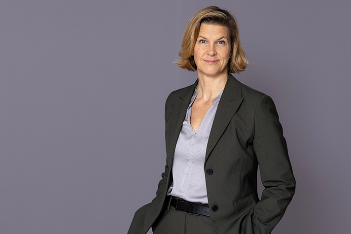 Jämställdhetsminister Nina Larsson tittar in i kameran med en bestämd min.