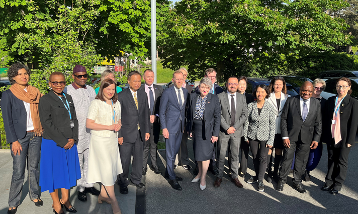 Gruppfoto med ett tjugotal personer utomhus. I mitten står socialminister Jakob Forssmed och Storbritanniens biträdande hälsominister Ashley Dalton.