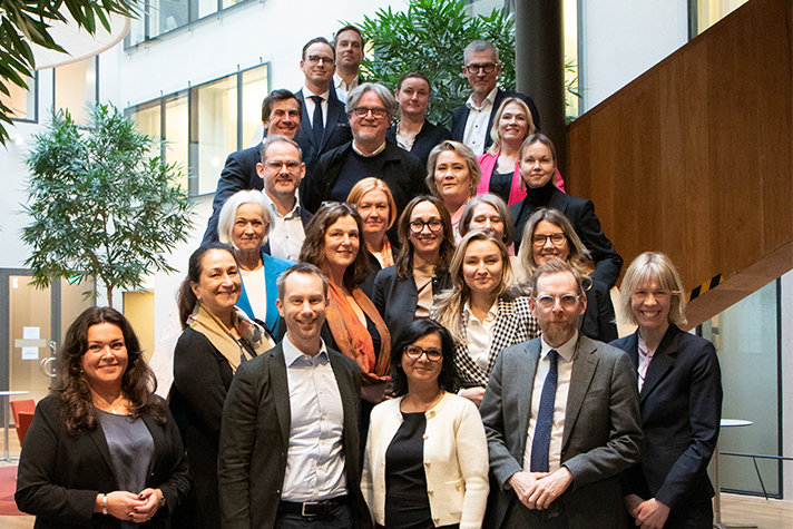 En grupp människor står tillsammans i en trappa och tittar in i kameran.